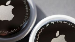 Close-up view of two Apple AirTags with the Apple logos partly visible.