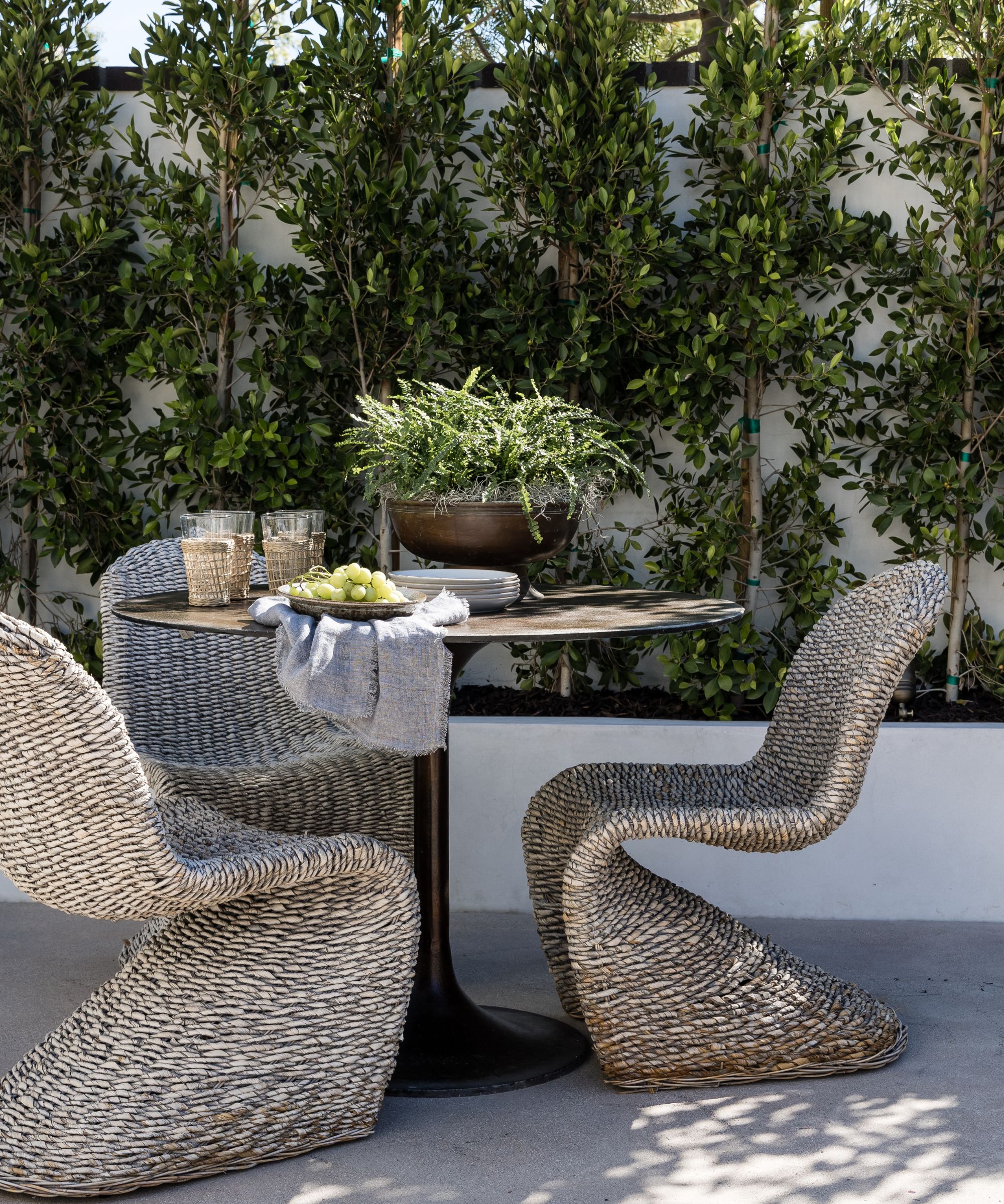 Small round outdoor table with statement rattan chairs