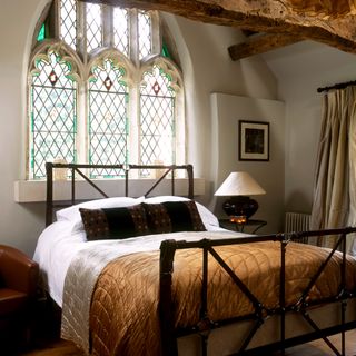 Bedroom iron bed arched gothic stained glass windows