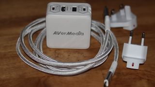 The AVerMedia Elite Go GC313 Pro charging brick and capture card combo in white.