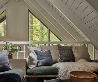 mezzanine seating space in cabin with white painted wood walls