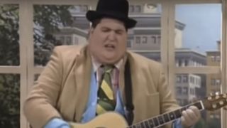 Jay Leggett playing guitar in front of a window on In Living Color