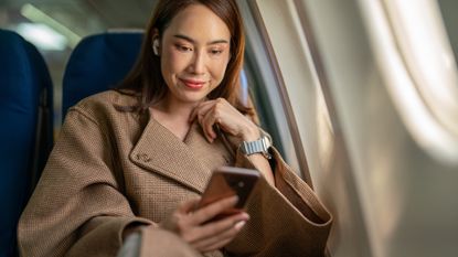Woman using phone on flight