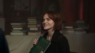 Madeline Brewer holding a book in You