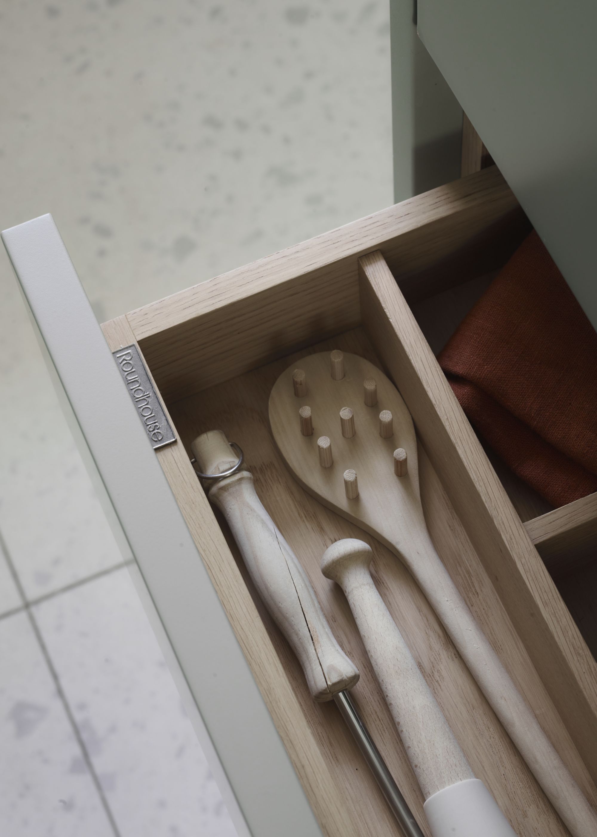 A kitchen drawer with wooden utensils as well as separators to section the zones