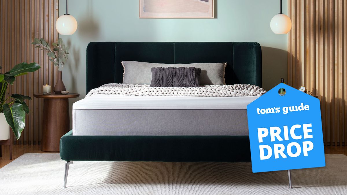 A Purple Hybrid Mattress on a bed frame in a bedroom with a Tom&#039;s Guide price drop deals graphic