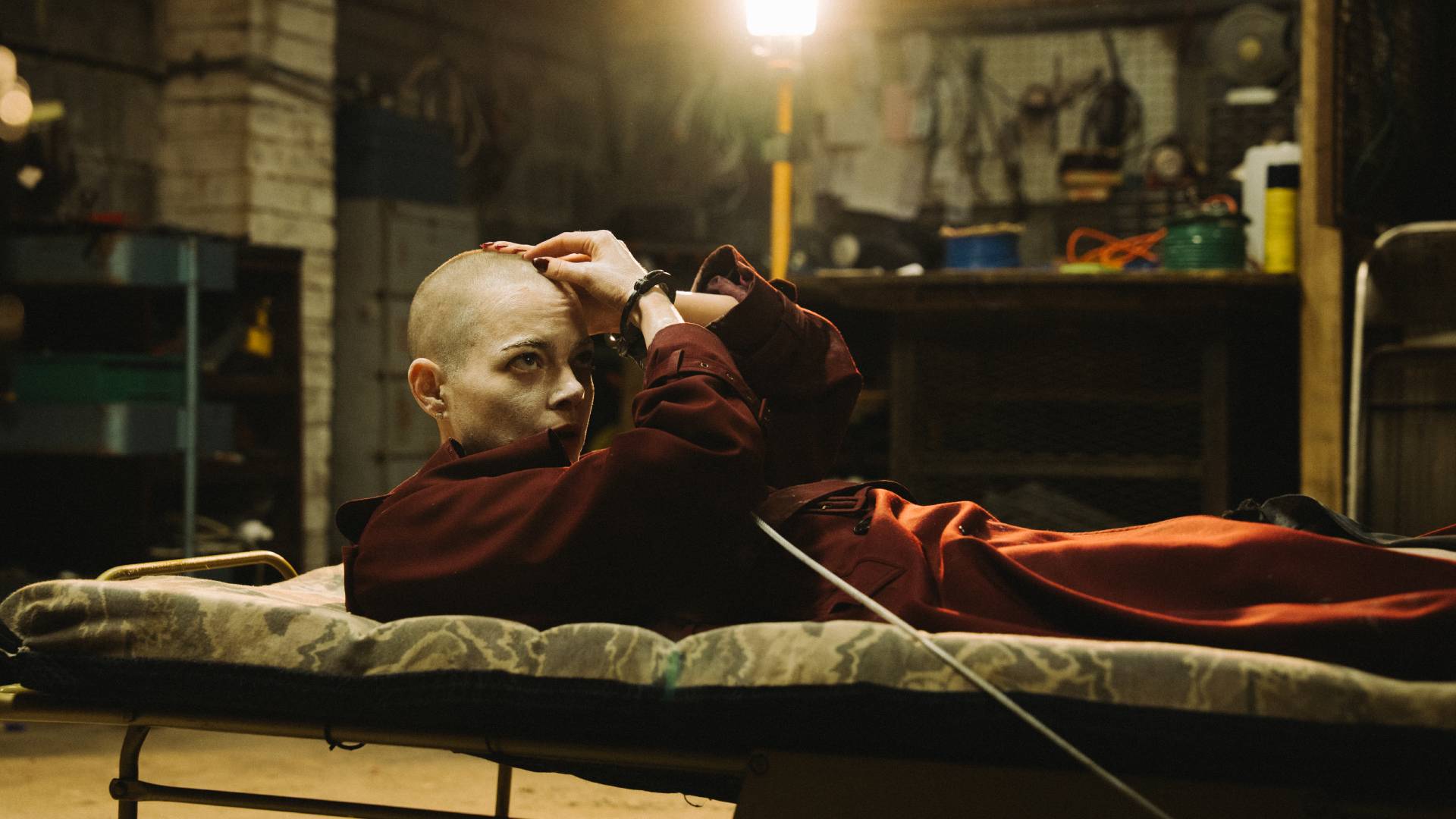 Emma Stone strapped to a bed with a bald head in Bugonia