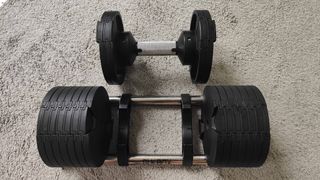 Closeup of the BLK BOX Adjustable Dumbbell on a carpeted floor