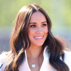 Meghan Markle smiles and looks away from the camera