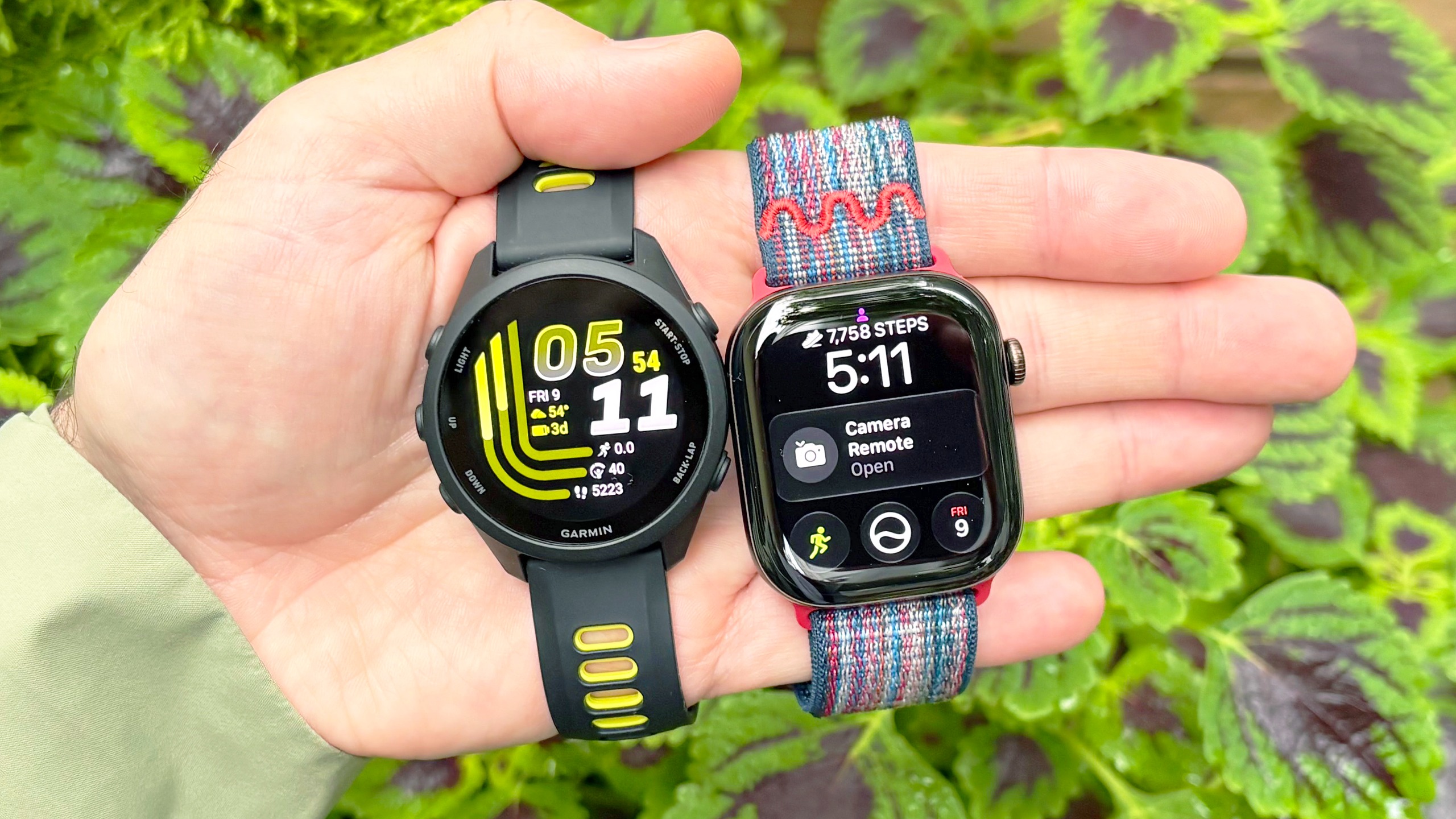 Close-up of the Apple Watch 12 and Garmin Forerunner in the writer's hand
