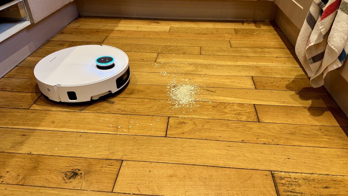 Dreame Matrix10 Ultra robot vacuum approaching a pile of oats on a wooden floor