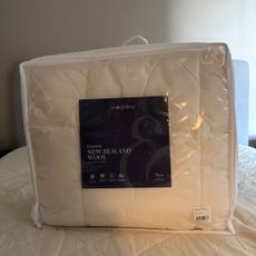 Mattress topper on a mattress on a grey bed in a bag