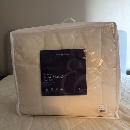 Mattress topper on a mattress on a grey bed in a bag