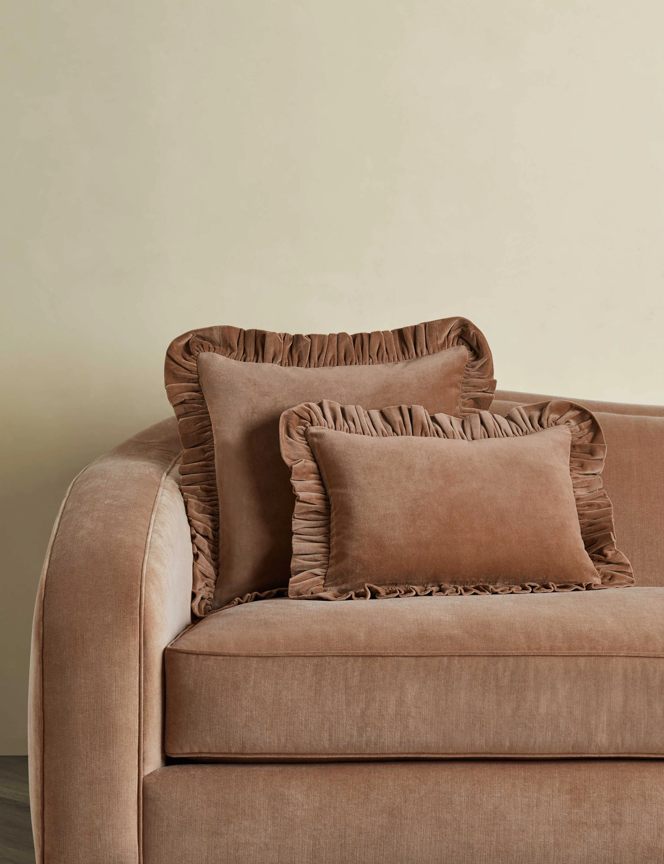 ruffle pink velvet pillows on a matching couch