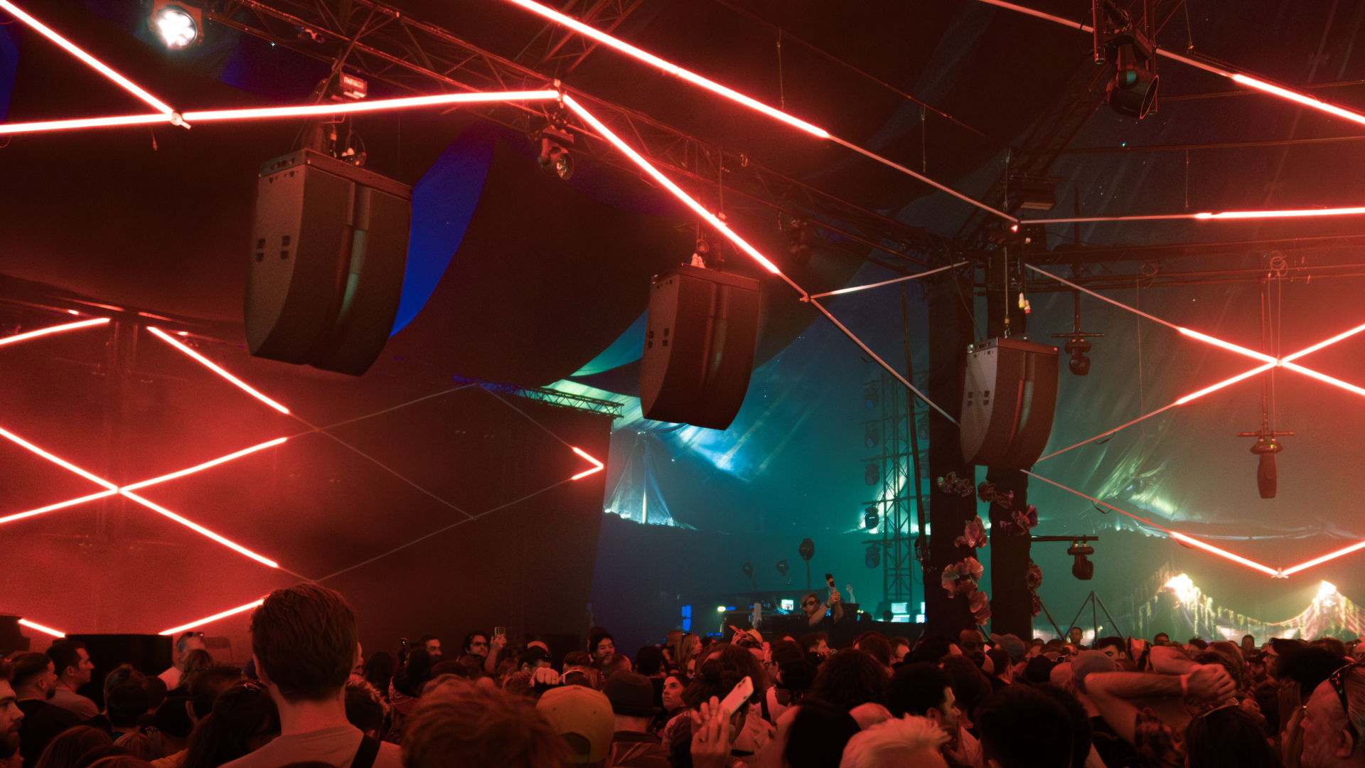 A shot of speakers hanging from concert rigging