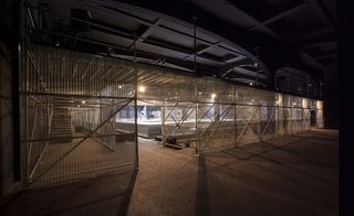 metallic mesh scaffolding, with all surfaces covered in the textile material and dramatically lit to enhance the geometric design of its elements