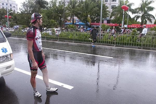 Australian David Kemp gets direction to his team car from his Fly V Australia teammates before he sees tour medical staff after he crashed heavily in the final kilometre of the stage.