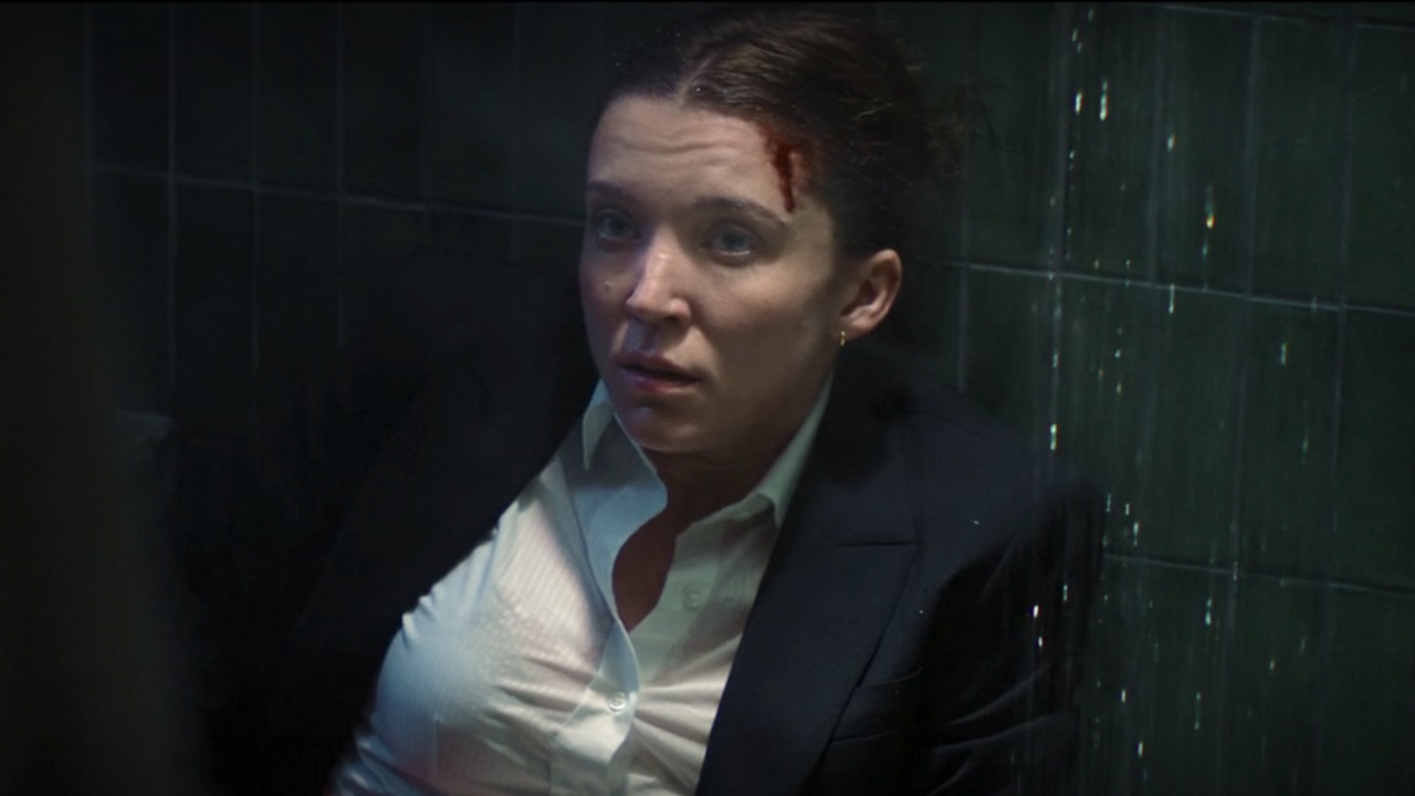 Jane sitting against shower wall with bleeding head and stab wound in Paradise Season 2 Episode 7