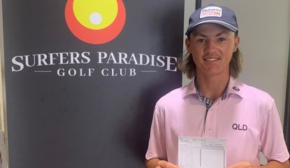 Billy Dowling poses with a scorecard in front of the Surfers Paradise Golf Club logo