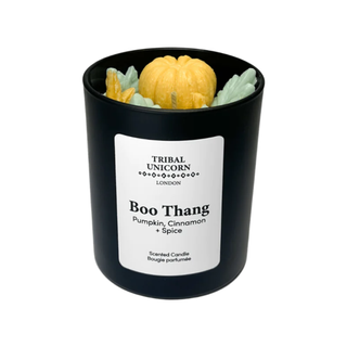 black candle reading 'boo thanks' with a yellow and green pumpkin design