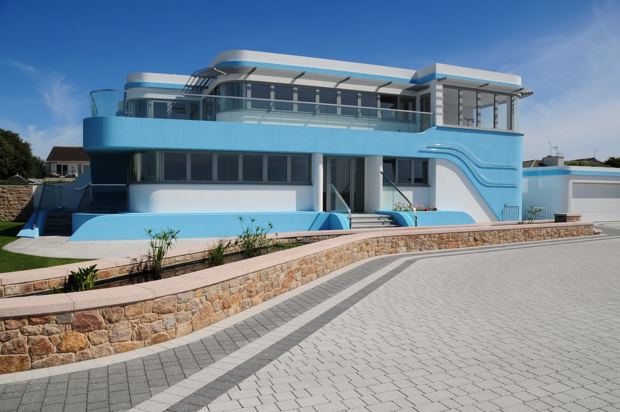 blue and white house with brick driveway