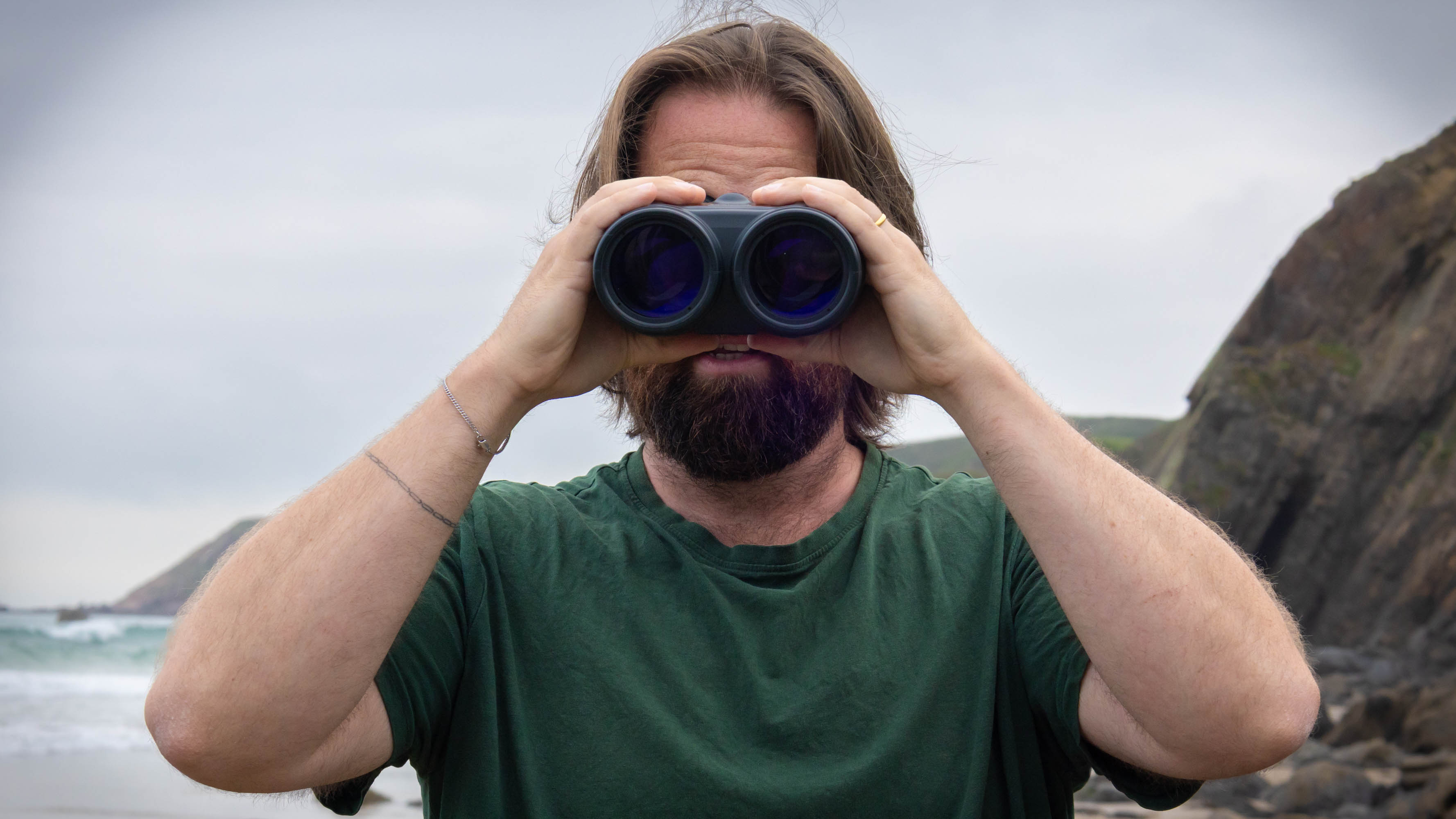 A male using the Canon 15x50 IS binoculars, looking directly at the camera to show the lenses.