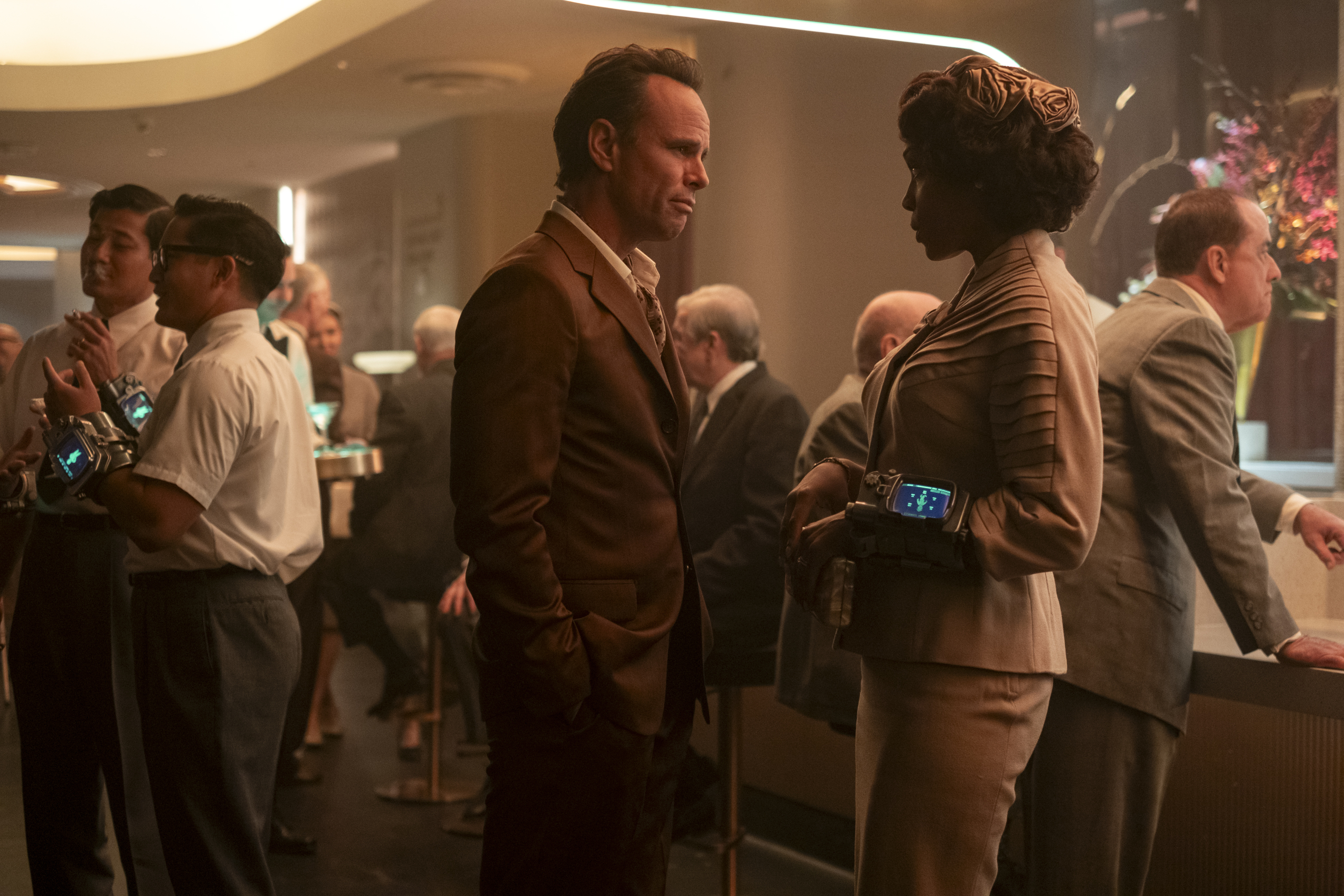 Walton Goggins, Frances Turner in suits at a party