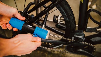 Image shows cyclist using one of the best bike locks to lock a bicycle