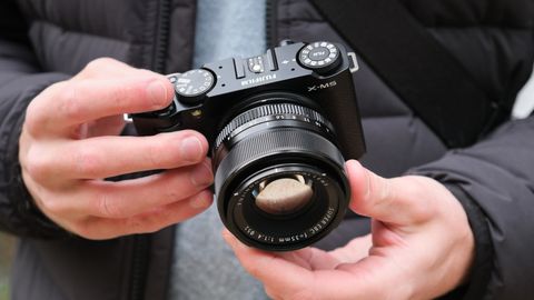 Fujifilm X-M5 camera with a Fujifilm 35mm lens attached held in a pair of hands