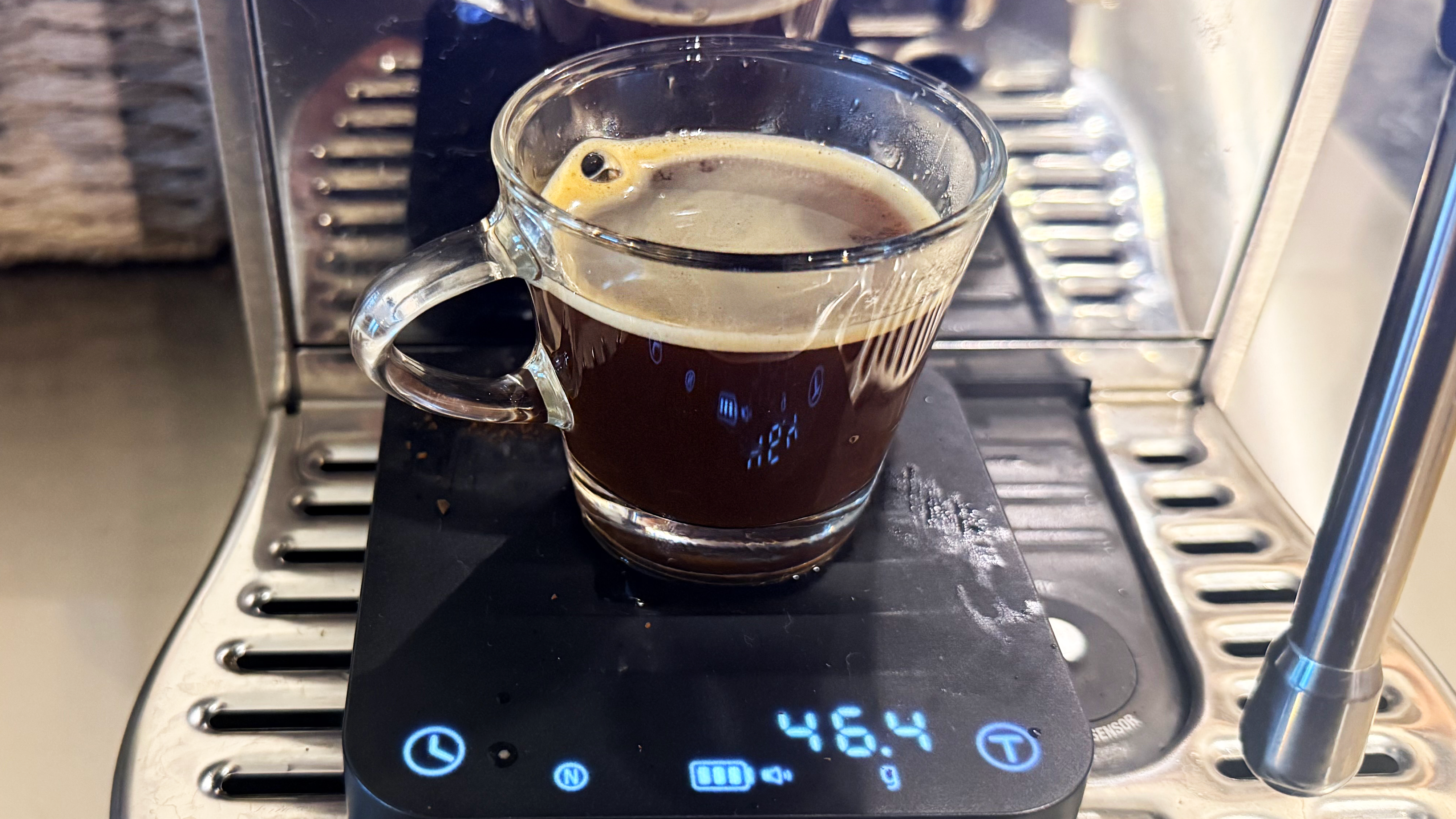 A photo of espresso made on the breville bambino plus espresso machine in a shot glass with the wacaco exagram pro scale
