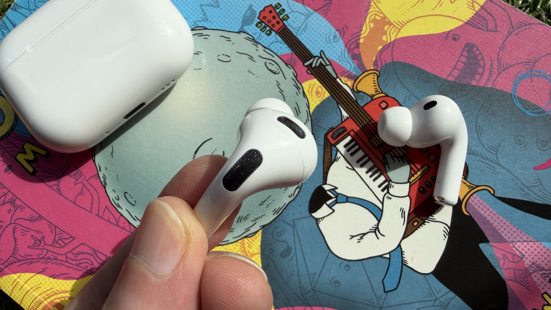 The AirPods Pro 3 earbuds from Apple against the pages of a graphic novel.