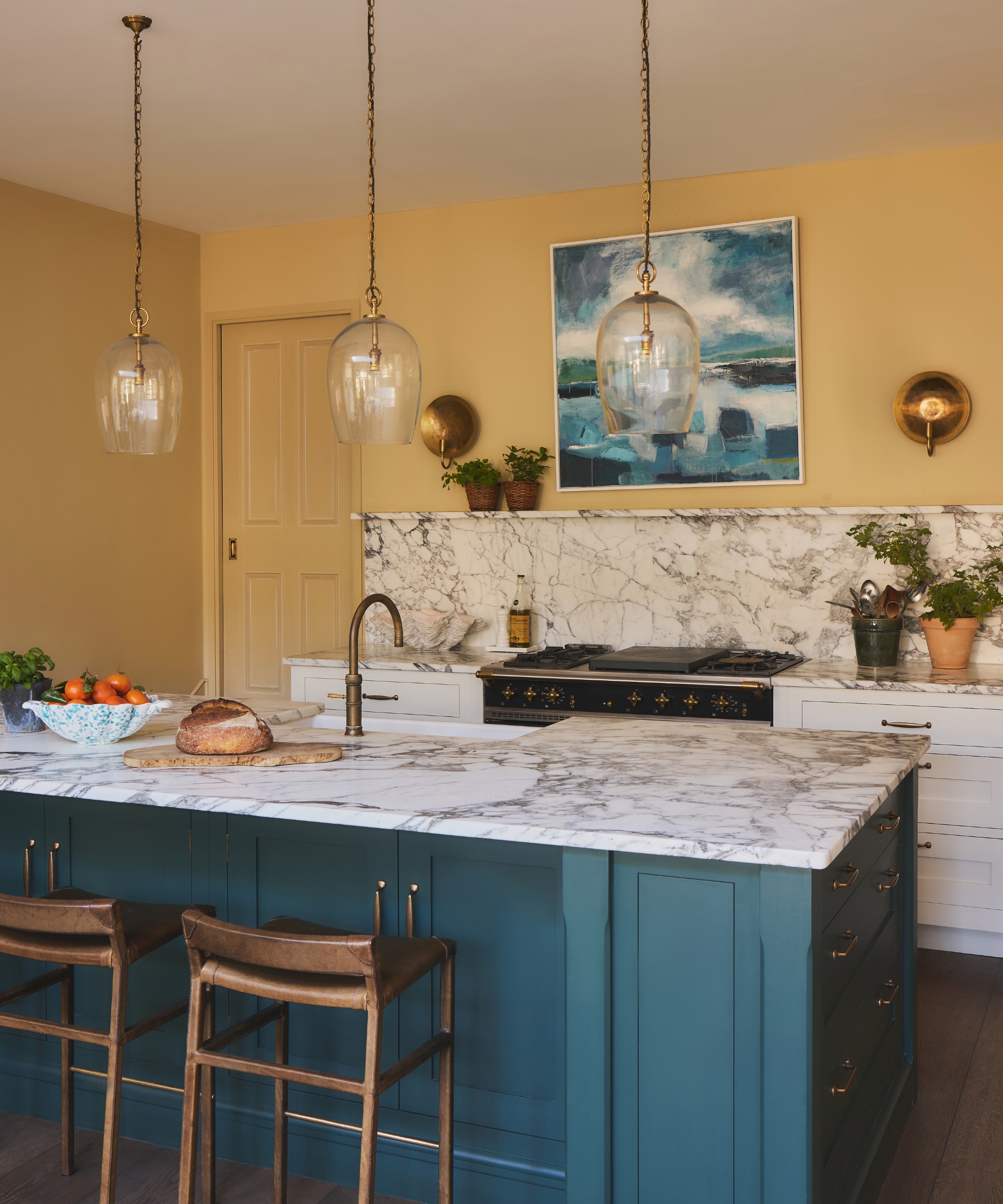 A small kitchen with straw yellow walls and a smoky blue-green island