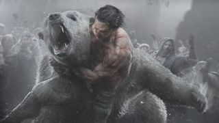 A man wrestling a polar bear while people watch