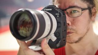 James Artaius holding the Canon EOS R1 with a telephoto zoom lens