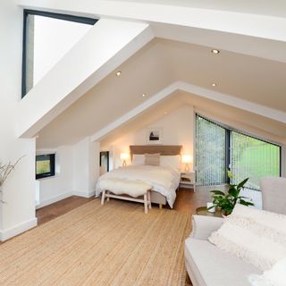 attic bedroom with white walls bed and wooden flooring