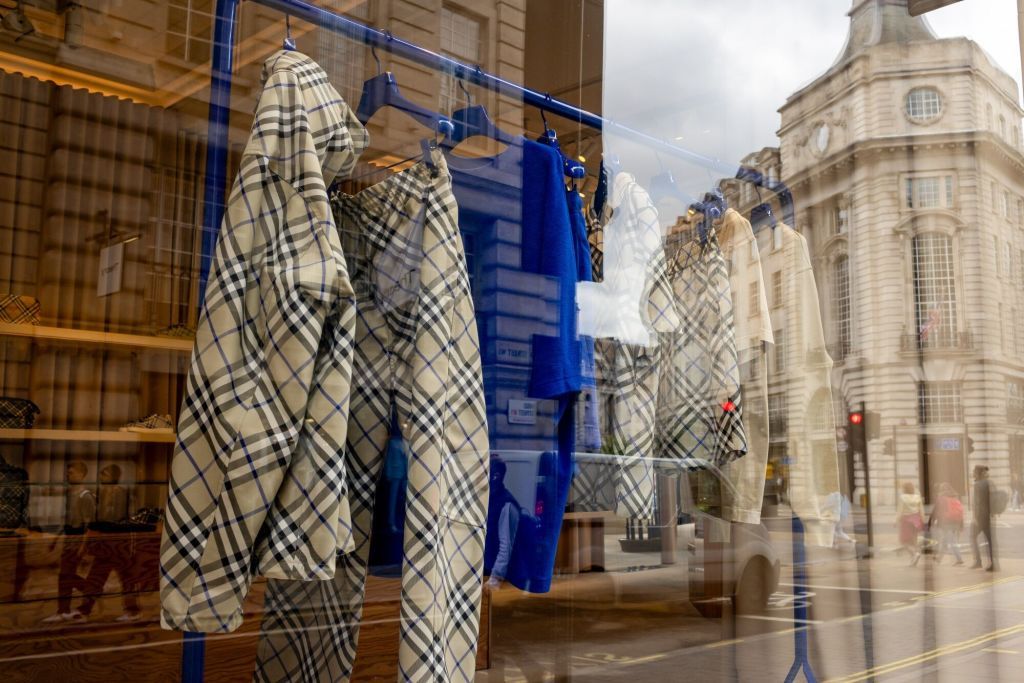 Clothes hanging on a rail in a window display at a Burberry boutique in London.