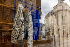 Clothes hanging on a rail in a window display at a Burberry boutique in London.