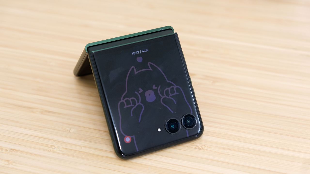 The Motorola Razr Plus 2026 in the hand and on a wooden table
