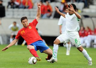 Spain's Xabi Alonso competes for the ball with Saudi Arabia's Ibrahim Ateef in a friendly ahead of the 2010 World Cup.