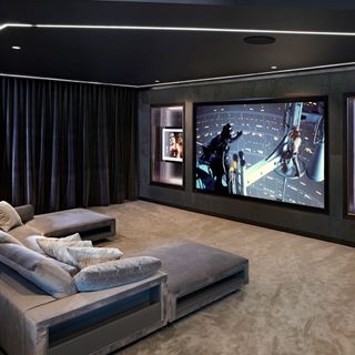 cinema room with big screen and grey sofa