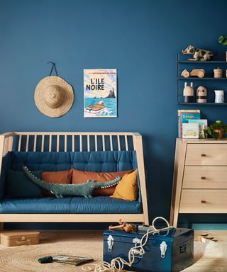 blue playroom with day bed, artwork, storage ideas, trunk