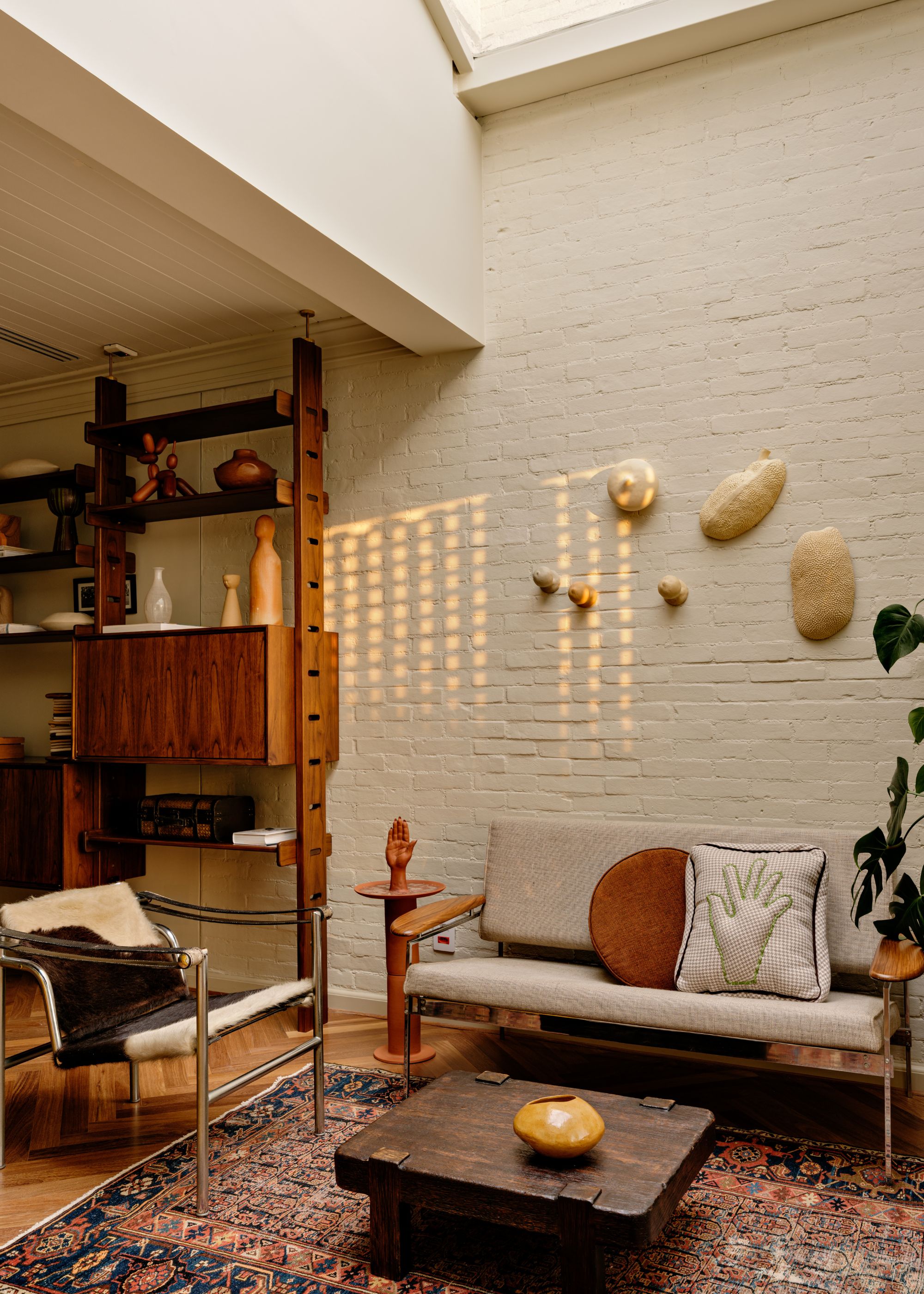 A home office with herringbone wooden flooring, and a seating area with the skylight above