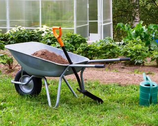 compost and topsoil in wheelbarrow in garden