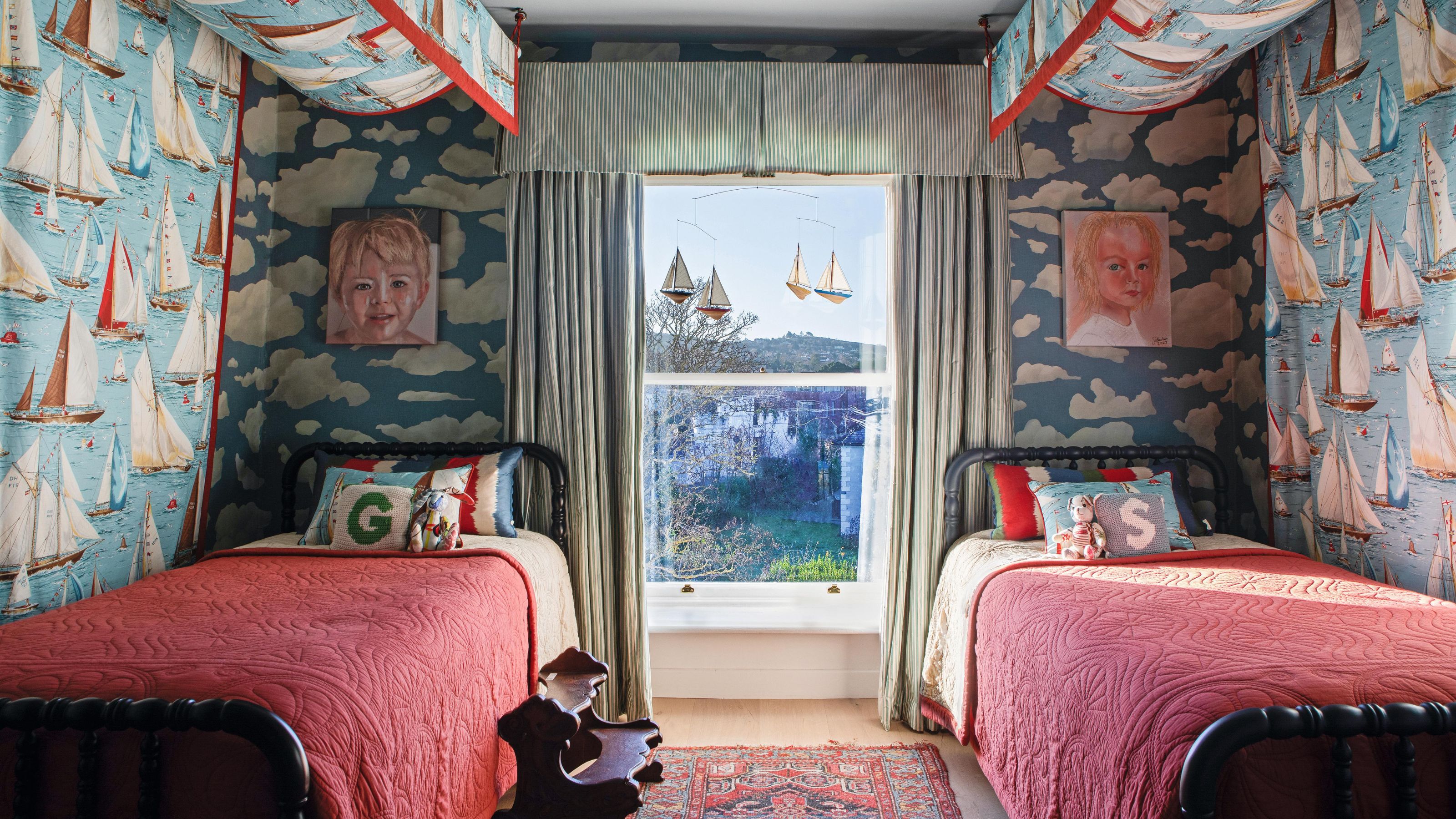 a little boys twin bedroom with blue cloud wallpaper and boat printed canopy beds