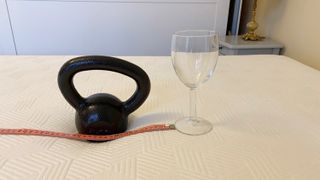 A kettlebell, a wine glass and a tape measure on the Panda Hybrid Bamboo mattress