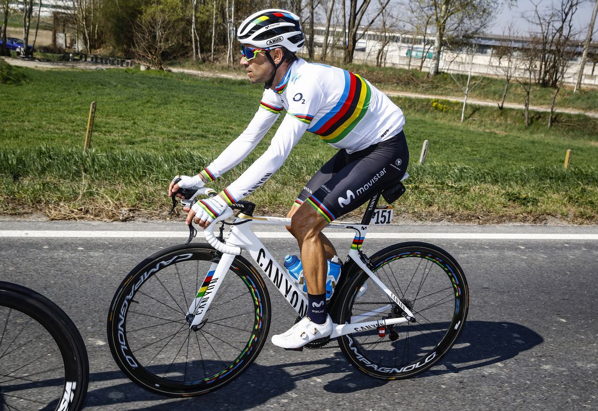 Alejandro Valverde rolls along, clad entirely in rainbow stripes.