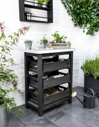 black and white storage unit with three drawers on a modern patio with white painted walls