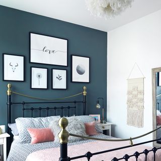 Navy bedroom with white prints above bed
