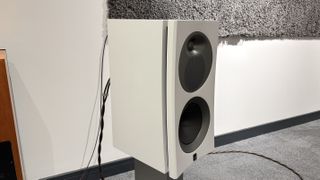 Arendal 1528 Bookshelf 8 standmount speakers on grey carpet in front of white wall 