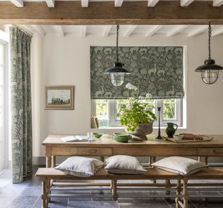 rustic dining room with matching curtains and blinds, stone flooring, cream walls